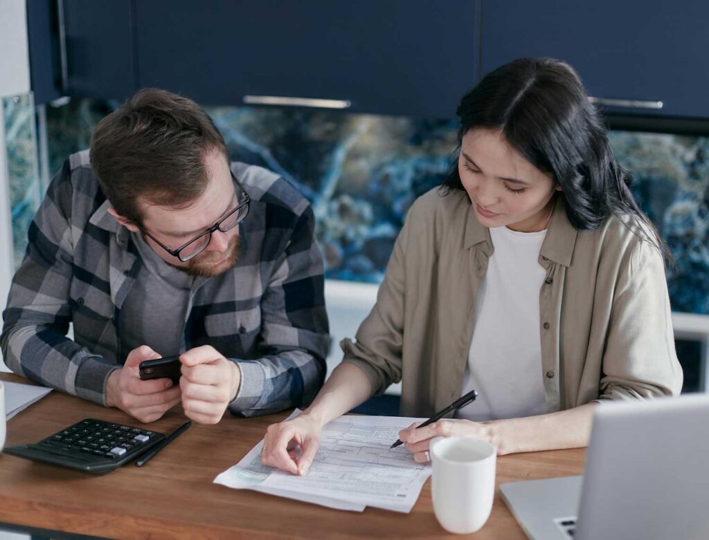 A mixed-race couple reviews paperwork in their kitchen