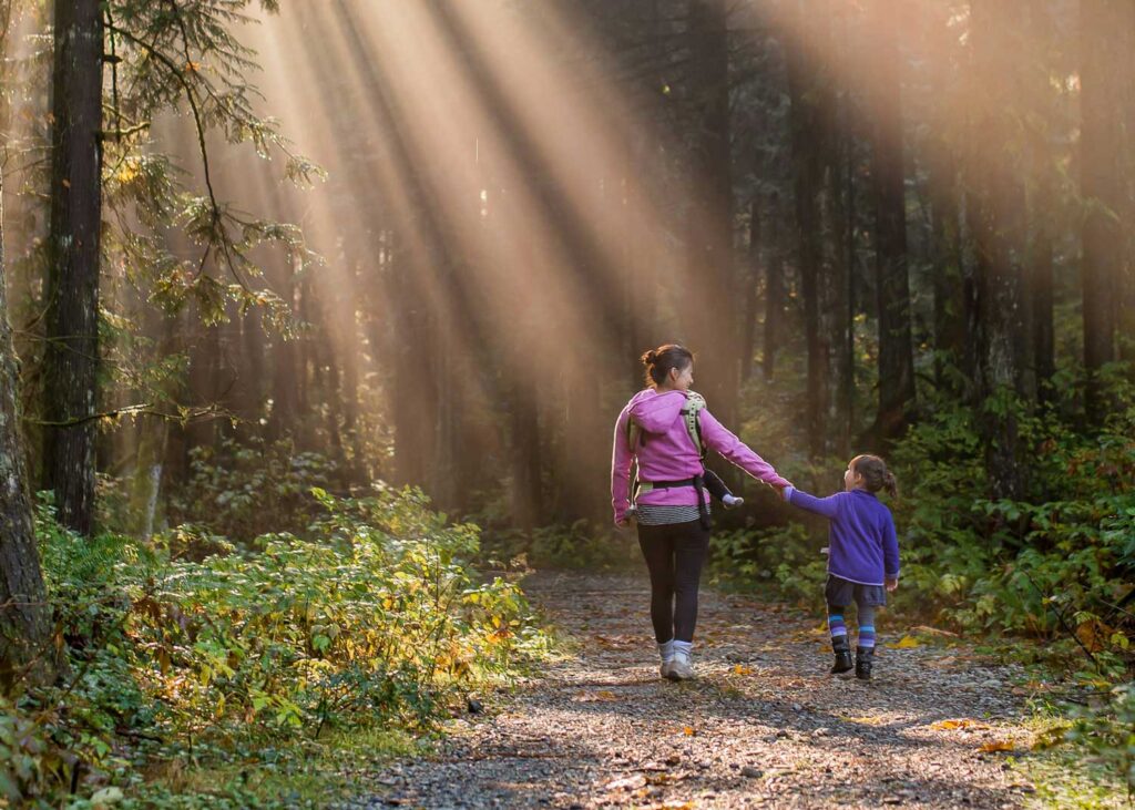 A mother and daughter take a walk in the woods